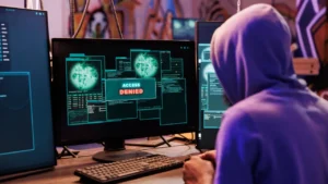 Google's AI Agent Big Sleep Becomes Hacker's Nightmare, Stops Cyber Attacks Before They Begin 4 Hacker wearing hoodie facing "Access Denied" message on computer screen